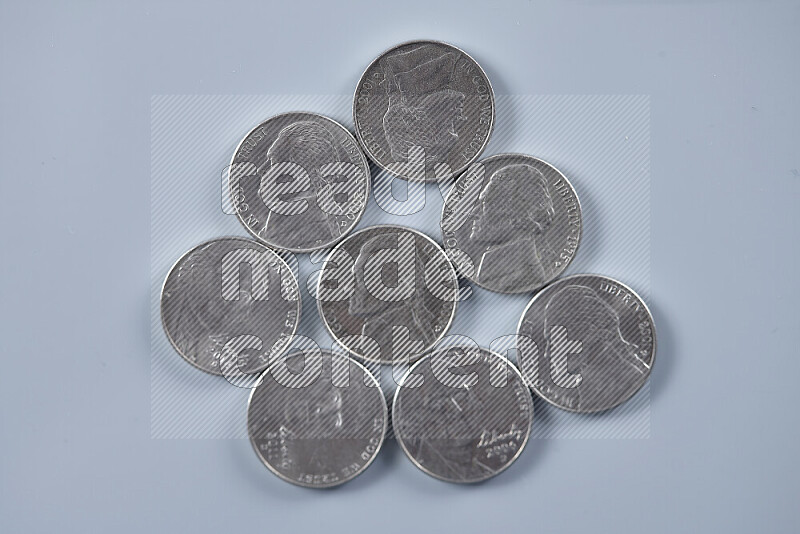 A close-up of scattered United States one dime coins on grey background