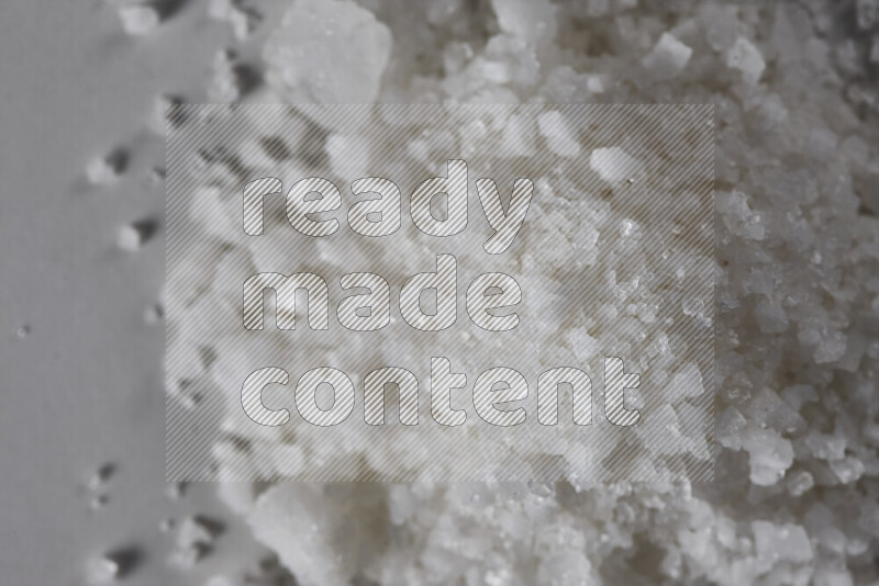 A bunch of coarse sea salt crystals on white background