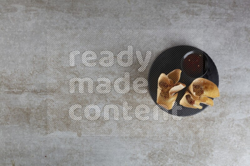 wonton cups with soy sauce ramkin on circle slate on grey textured counter top