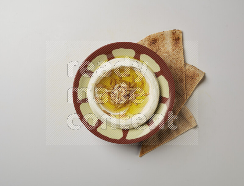 Lebnah garnished with pine nuts in a traditional plate on a white background
