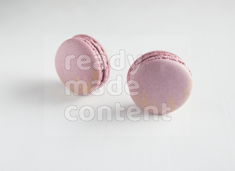 45º Shot of two Purple Strawberry macarons on white background