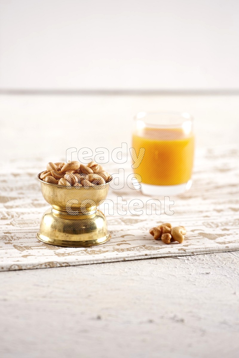 Nuts in a metal bowl with qamar eldin in a light setup