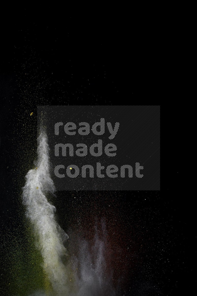 A side view of multicolored powder explosion on black background