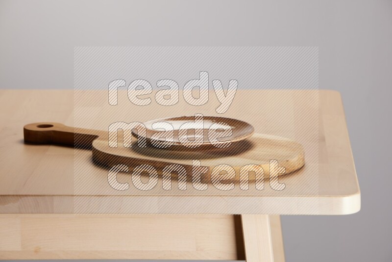 multi colored plate placed on a  wooden oval cutting board on the edge of wooden table