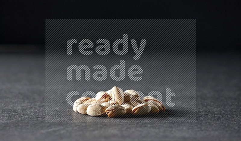 A bunch of pistachios on a black background in different angles