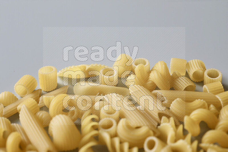 Different pasta types on light blue background