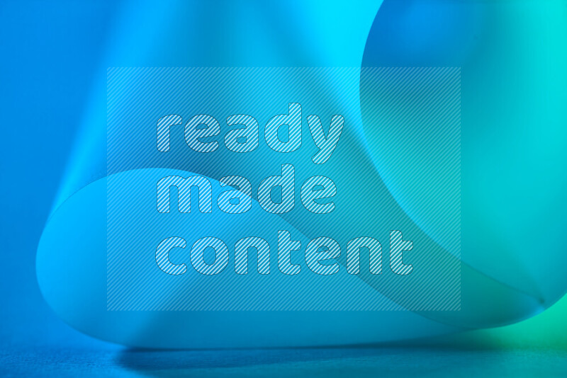 فن تجريدي يعرض منحنيات وتدرجات اللون الأخضر والأزرق مكونه بضوء ملون