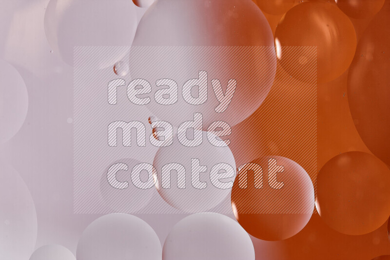Close-ups of abstract oil bubbles on water surface in shades of white and orange