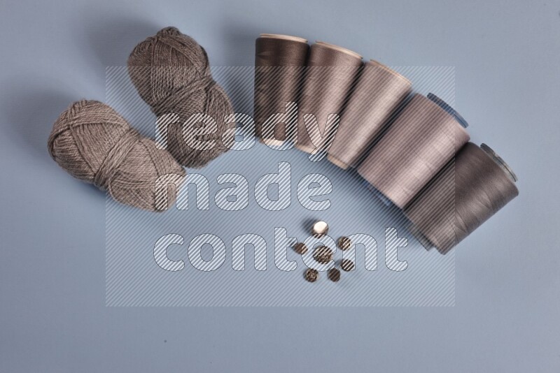 مجموعة من أدوات الخياطة والتفصيل رمادية اللون على خلفية زرقاء