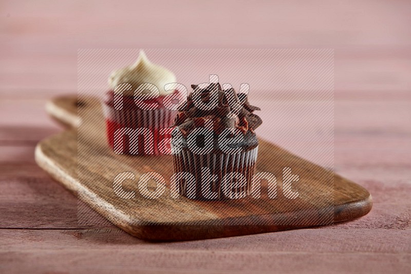 Chocolate mini cupcake topped with chocolate curls on a wooden board