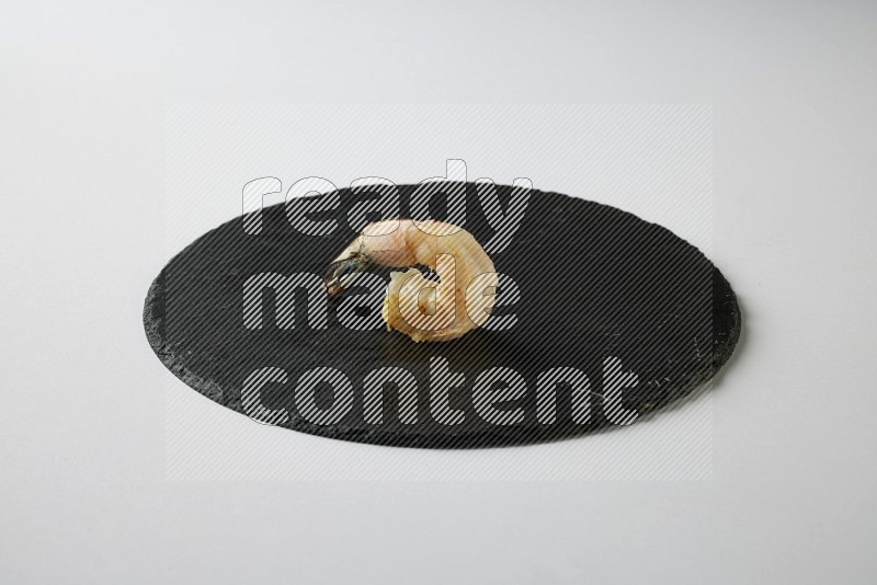 one  grilled shrimp  on a black slate direct  on a white back ground