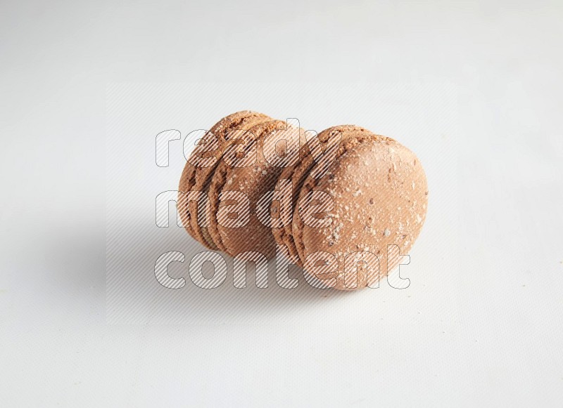 45º Shot of two Brown Hazelnuts macarons on white background