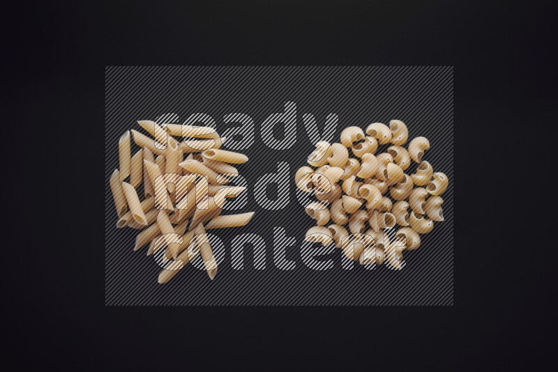 Different pasta types in bunches on black background