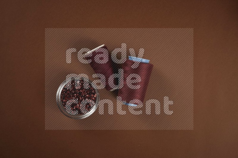 Red sewing supplies on brown background