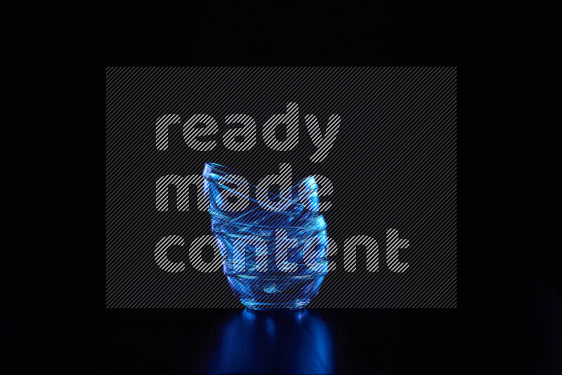 Glassware with rim light in blue against black background