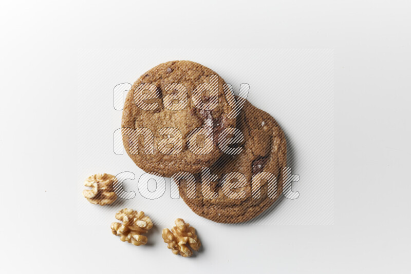 Chocolate chips cookies with walnuts beside it on a white background