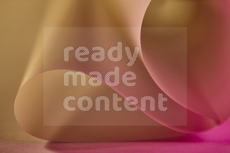 فن تجريدي يعرض منحنيات وتدرجات اللون الذهبي والوردي مكونه بضوء ملون