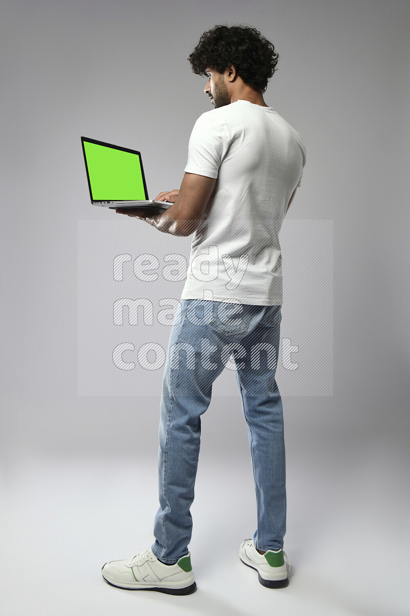 A man wearing casual standing and showing a laptop screen on white background