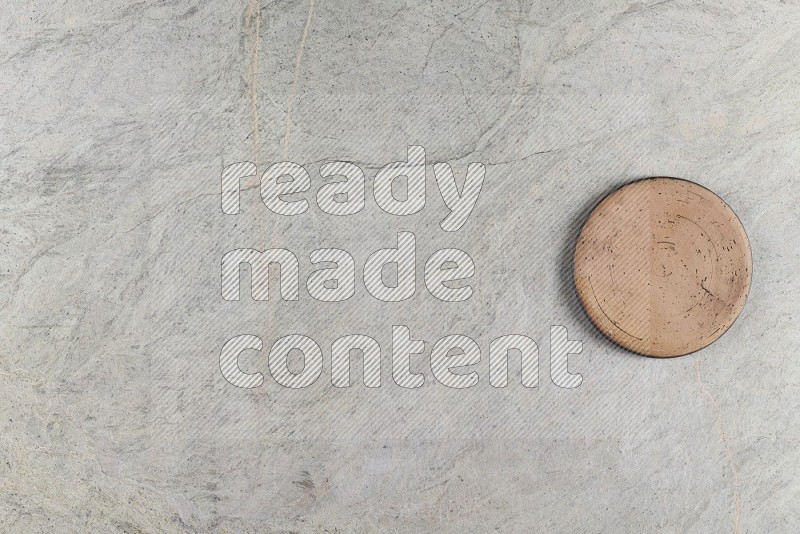 Top View Shot Of A Pottery Coaster On Grey Marble Flooring