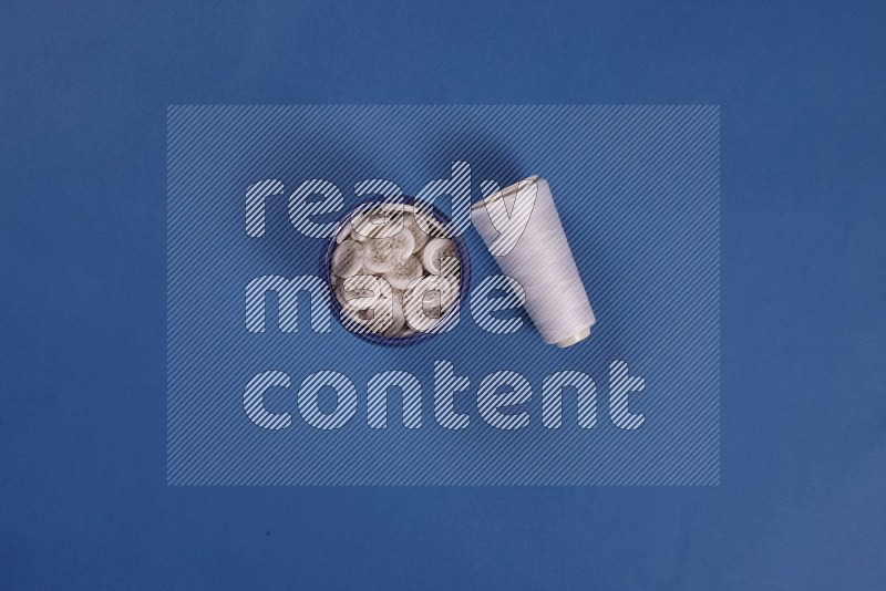 White sewing supplies on blue background