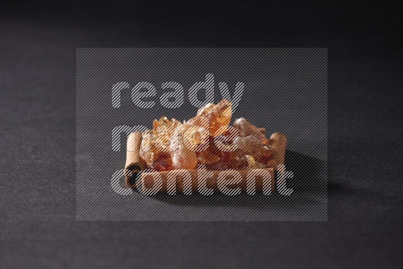 A single square of cinnamon sticks full of Arabic gum on black flooring