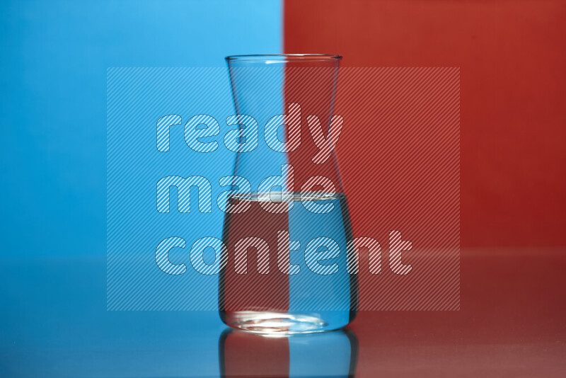 The image features a clear glassware filled with water, set against blue and red background