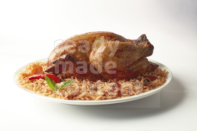 red basmati Rice with  whole roasted chicken on a white rounded plate  direct  on white background