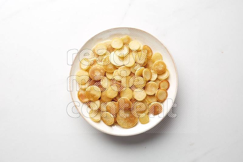 Top-view shot of plain cereal pancakes in a round bowl on white background