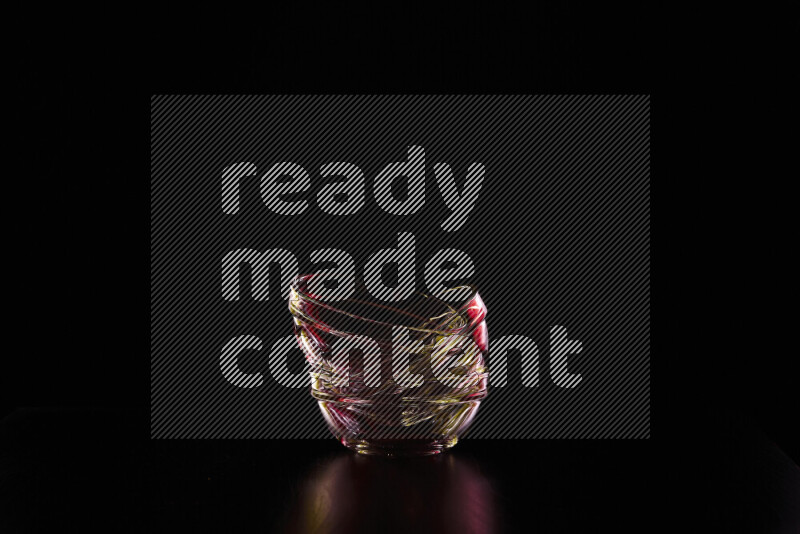 Glassware with rim light in red and yellow against black background