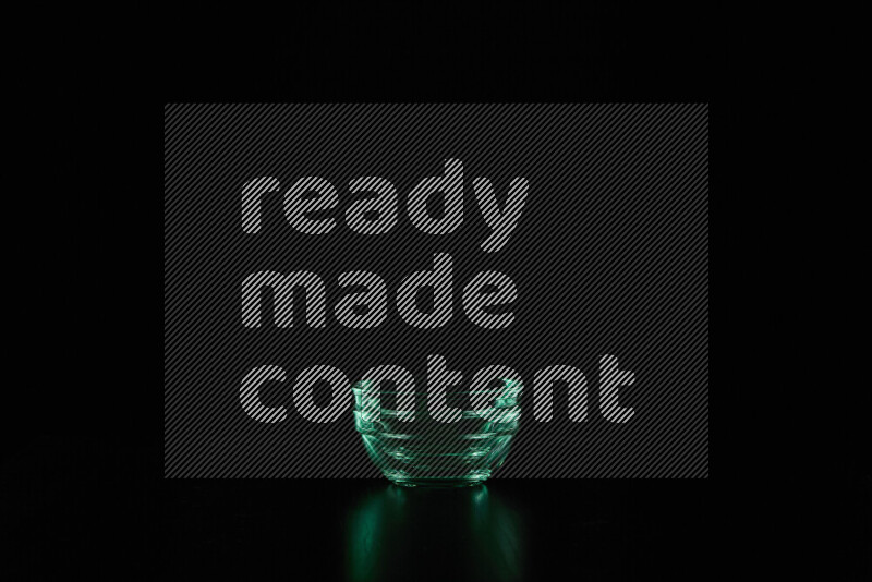 Glassware with rim light in green against black background