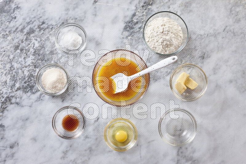 Cookies step by step with its ingredient, flour, butter, brown sugar, egg, vanilla extract, white sugar, chocolate chips and baking soda on grey marble background
