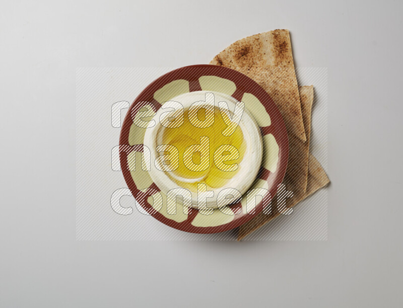 Lebnah garnished with olive oil in a traditional plate on a white background