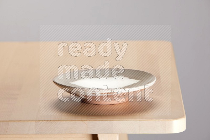 multi-colored pottery Plate on a wooden table edge