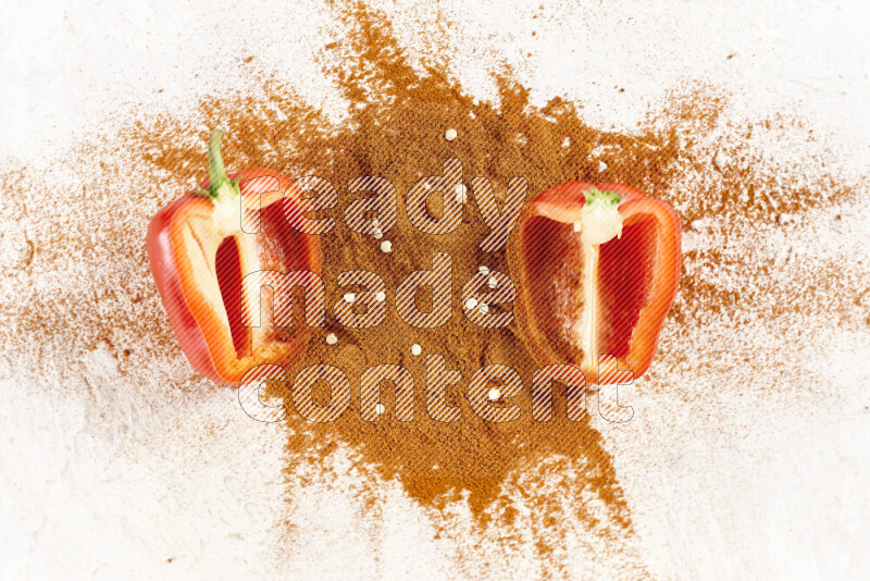 A bunch of ground paprika powder with two halfs of red bell pepper on white background