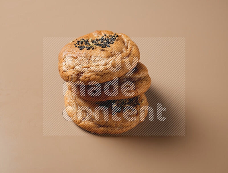 Hasawi cookies field with date and decorated by black seed and Anise grain on a brown background