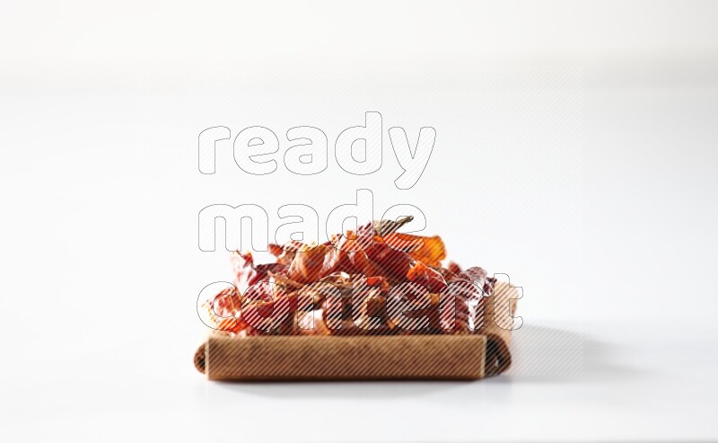 A single square of cinnamon sticks full of chilis on white flooring