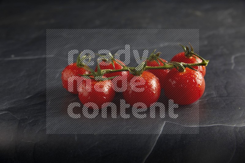 Red cherry tomato vein on a textured black slate background 45 degree