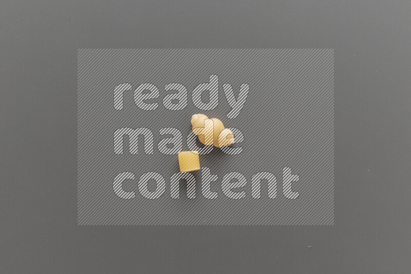 Big rings pasta with other types of pasta on grey background