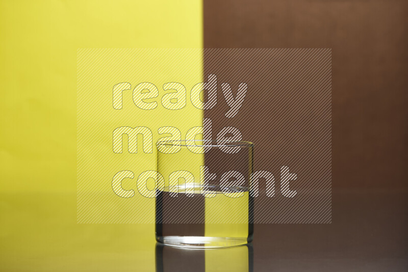 The image features a clear glassware filled with water, set against yellow and brown background