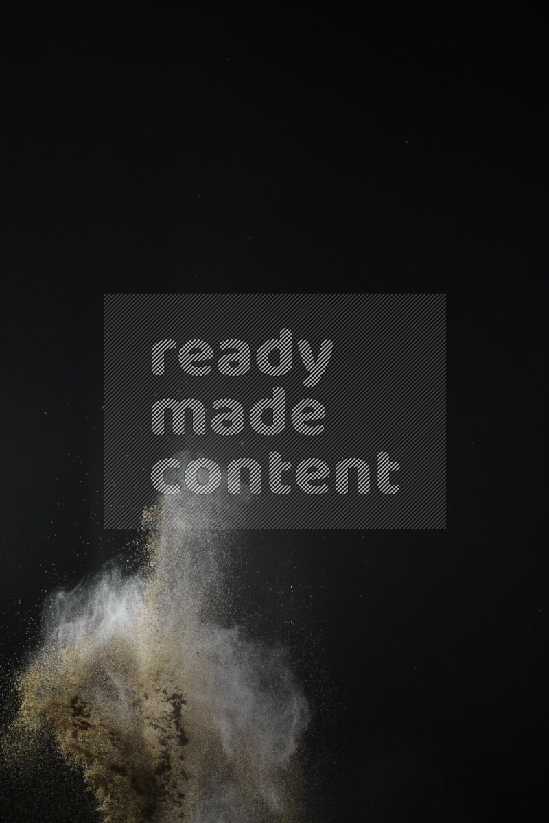 A side view of brown powder explosion on black background