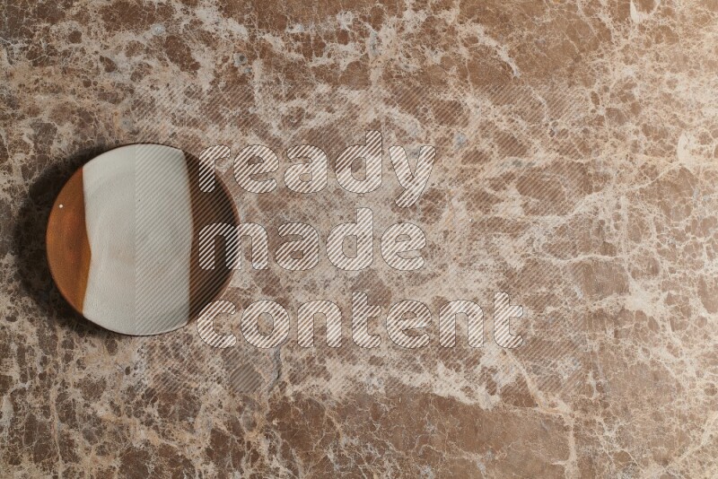 A decorative pottery plate on beige marble background