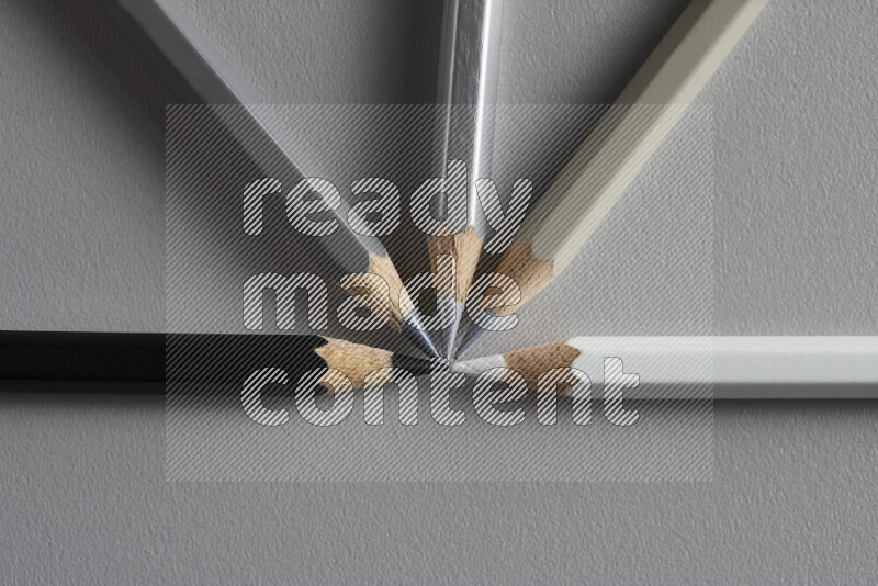 An arrangement of colored pencils in different colors on grey background