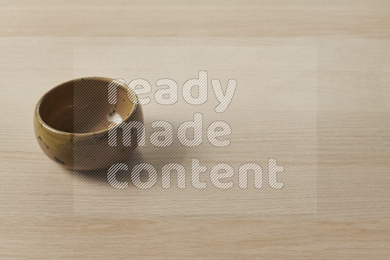 A multicolored pottery bowl on light wooden background