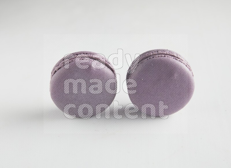 45º Shot of two Purple Blueberry macarons on white background
