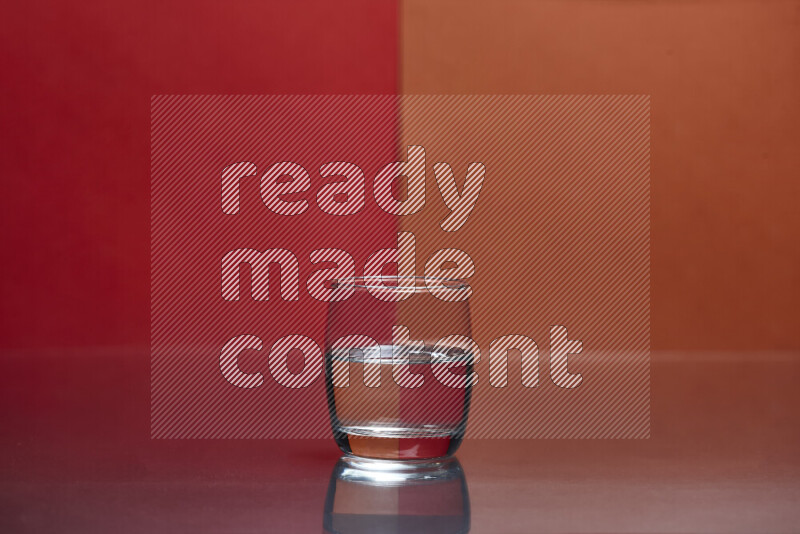 The image features a clear glassware filled with water, set against red and dark orange background