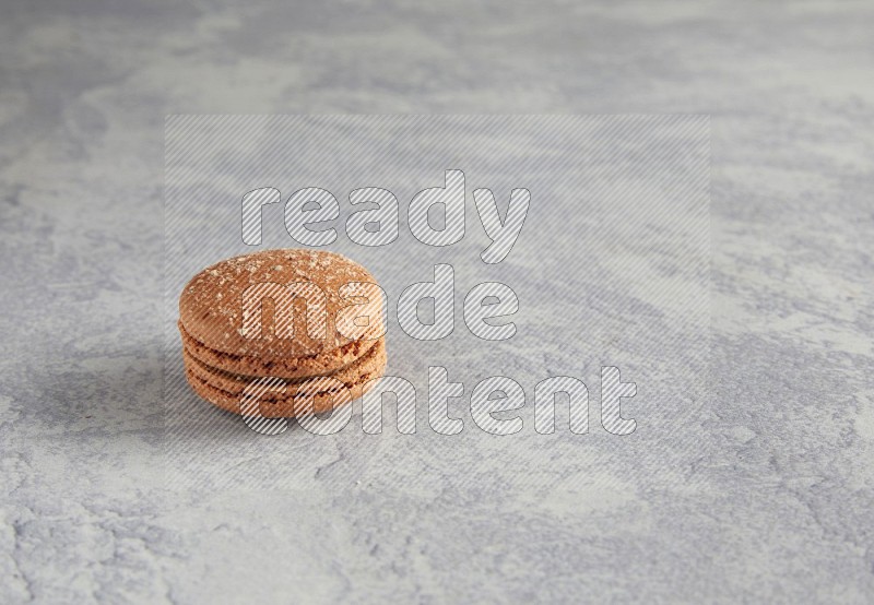 45º Shot of Brown Hazelnuts macaron on white  marble background