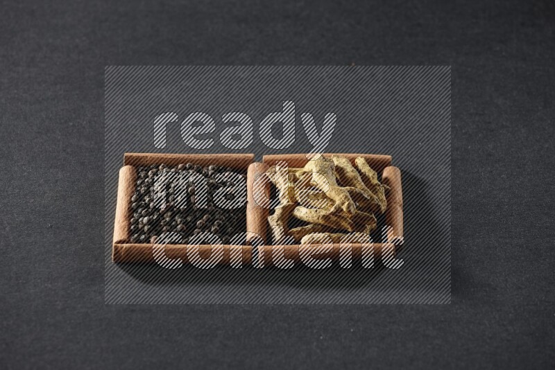 2 squares of cinnamon sticks full of black peppers and turmeric fingers on black flooring