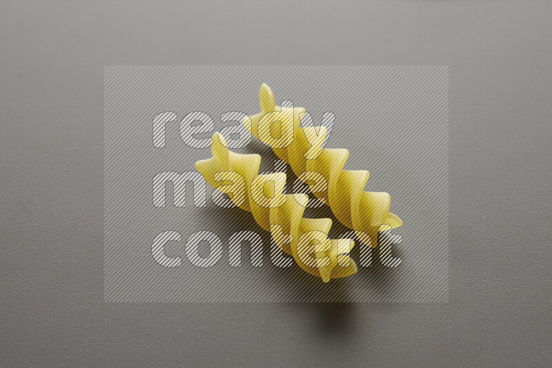 Fusilli pasta on grey background