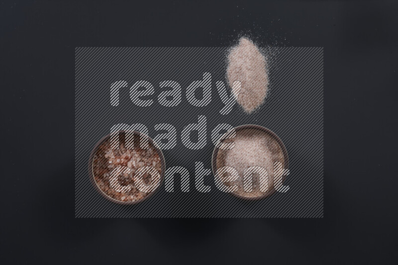 وعاء فخاري ممتلئ بملح الهيمالايا الناعم وملح الهيمالايا الخشن على خلفية سوداء