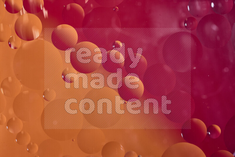 لقطات مقربة لفقاعات من الزيت على سطح الماء باللون الأحمر والبرتقالي